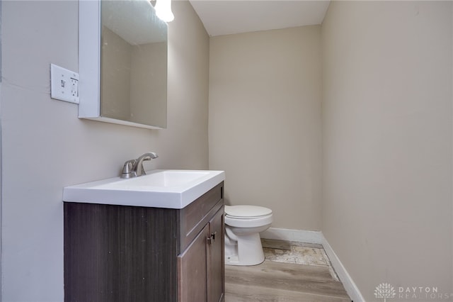 bathroom with vanity, wood-type flooring, and toilet