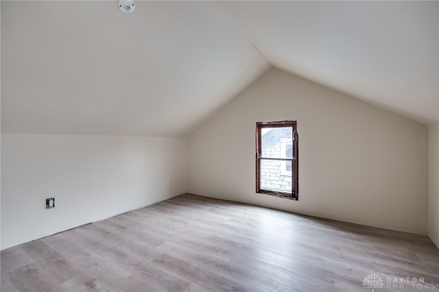 bonus room with lofted ceiling and light wood-type flooring