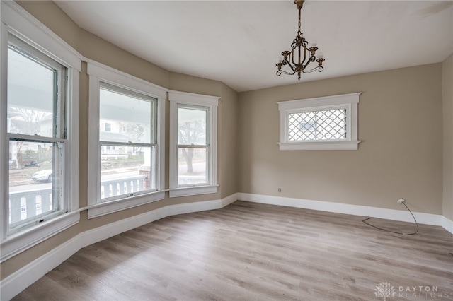 unfurnished dining area featuring light hardwood / wood-style flooring and a notable chandelier