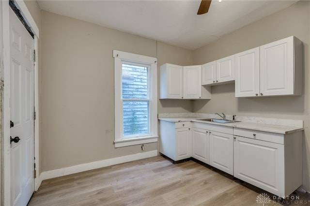 kitchen featuring light hardwood / wood-style floors, white cabinetry, and sink