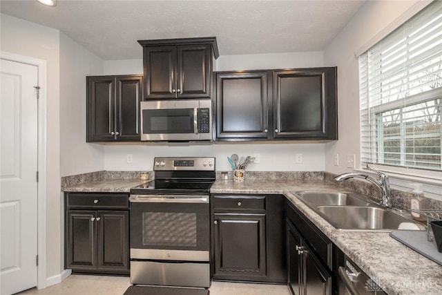 kitchen featuring a textured ceiling, sink, and stainless steel appliances