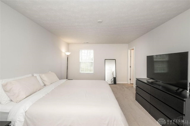 bedroom with a textured ceiling and light carpet