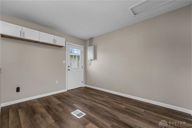 interior space featuring electric panel and dark hardwood / wood-style floors