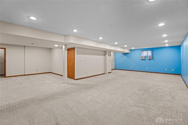 basement with a textured ceiling and light carpet