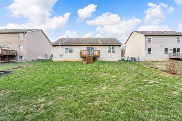 rear view of property featuring a yard and a wooden deck