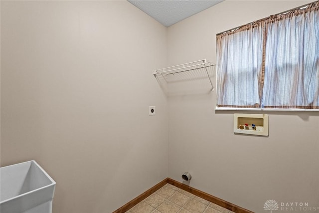 laundry area featuring hookup for an electric dryer, sink, hookup for a washing machine, and a textured ceiling