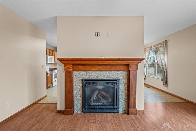 room details with hardwood / wood-style flooring, white appliances, and a fireplace