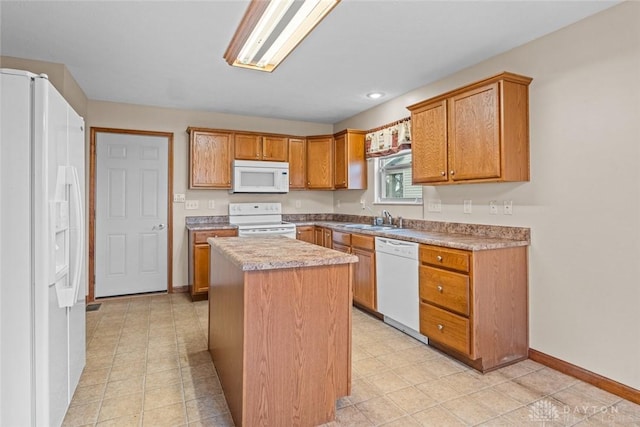 kitchen featuring a kitchen island, white appliances, sink, and light tile patterned floors