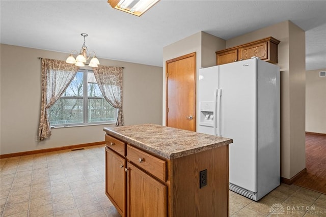 kitchen featuring decorative light fixtures, light hardwood / wood-style flooring, a chandelier, a center island, and white fridge with ice dispenser