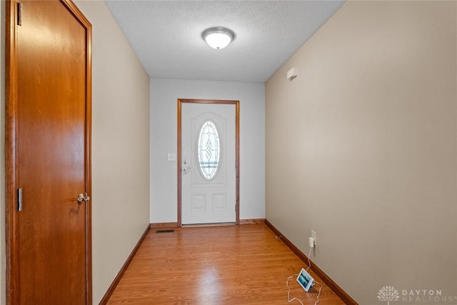 entryway featuring a textured ceiling and light wood-type flooring