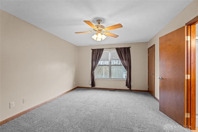 carpeted spare room with ceiling fan and a textured ceiling