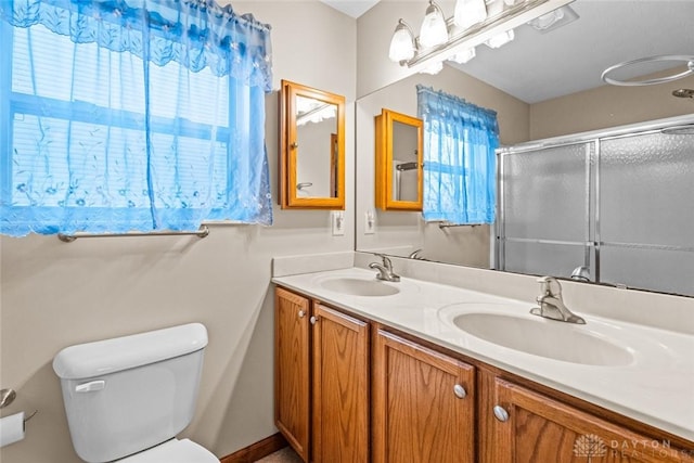 bathroom with walk in shower, vanity, and toilet