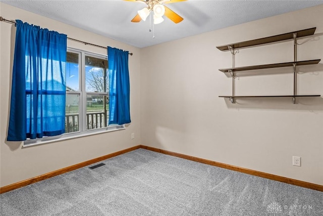 spare room with carpet flooring, ceiling fan, and a textured ceiling