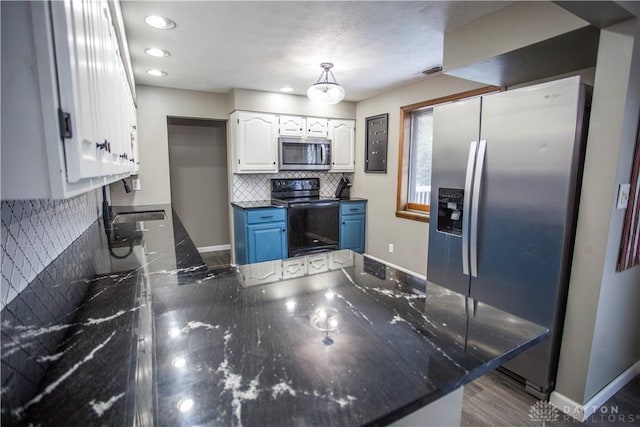 kitchen with kitchen peninsula, appliances with stainless steel finishes, blue cabinets, dark hardwood / wood-style floors, and white cabinetry