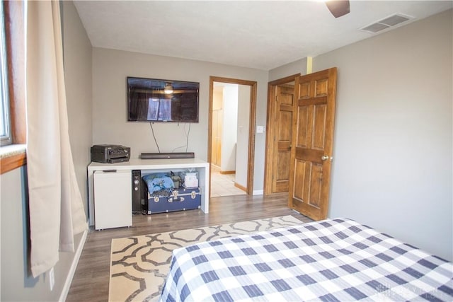 bedroom featuring hardwood / wood-style floors, white refrigerator, and ceiling fan