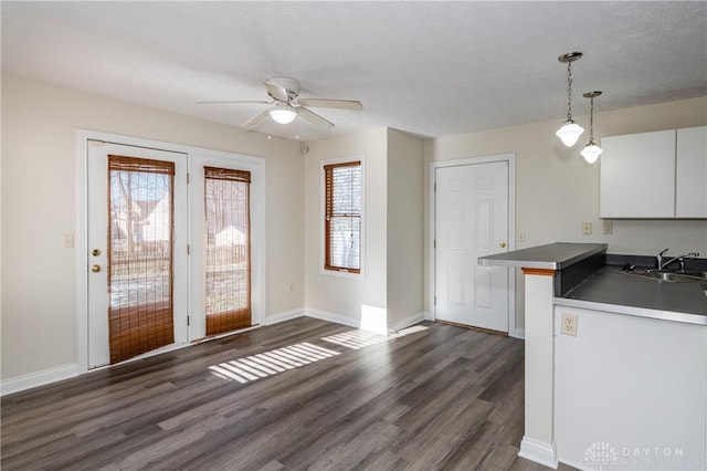 kitchen featuring white cabinetry, pendant lighting, a healthy amount of sunlight, and dark hardwood / wood-style floors