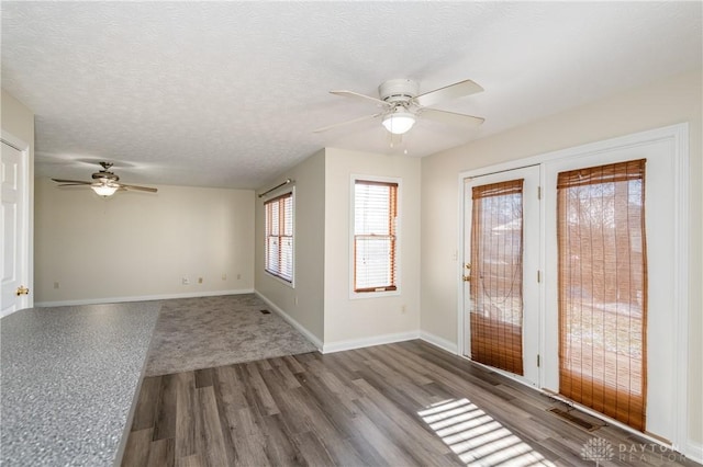 interior space featuring ceiling fan, hardwood / wood-style floors, and a textured ceiling