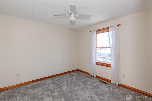 carpeted empty room featuring ceiling fan and a textured ceiling