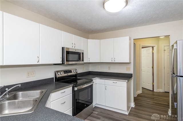 kitchen featuring dark hardwood / wood-style flooring, white cabinetry, sink, and appliances with stainless steel finishes