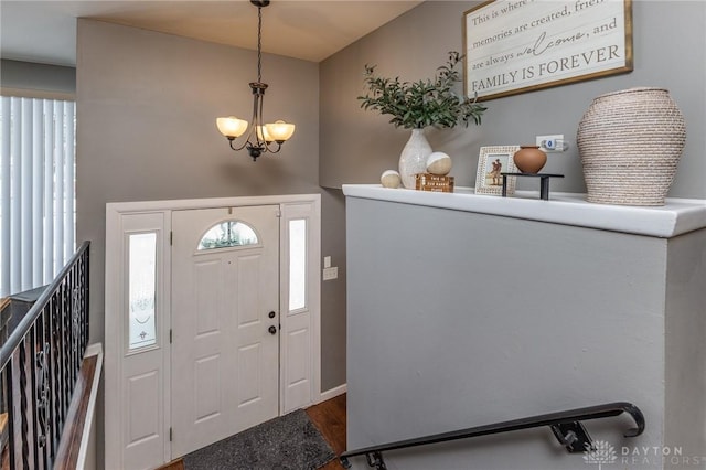 foyer entrance with an inviting chandelier and hardwood / wood-style flooring