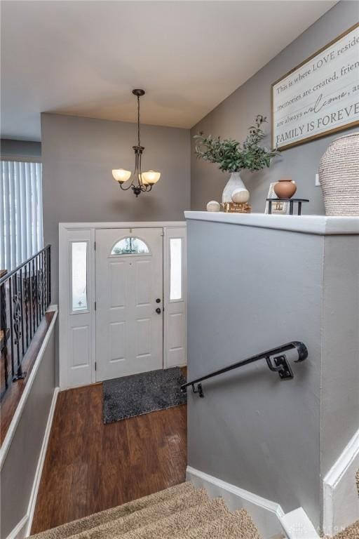 foyer entrance featuring plenty of natural light, wood-type flooring, and a notable chandelier