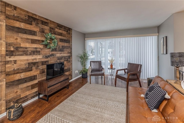 living room with dark wood-type flooring and wooden walls