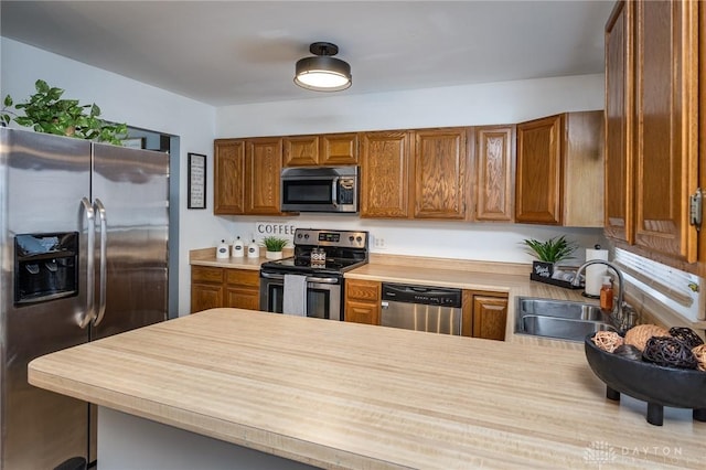 kitchen featuring kitchen peninsula, appliances with stainless steel finishes, and sink