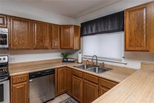 kitchen featuring light tile patterned flooring, appliances with stainless steel finishes, and sink