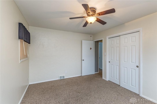 unfurnished bedroom with ceiling fan, carpet, and a closet