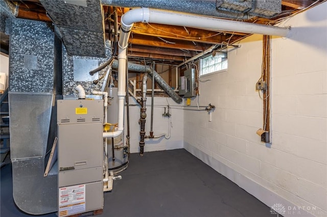 utility room featuring heating unit, gas water heater, and electric panel