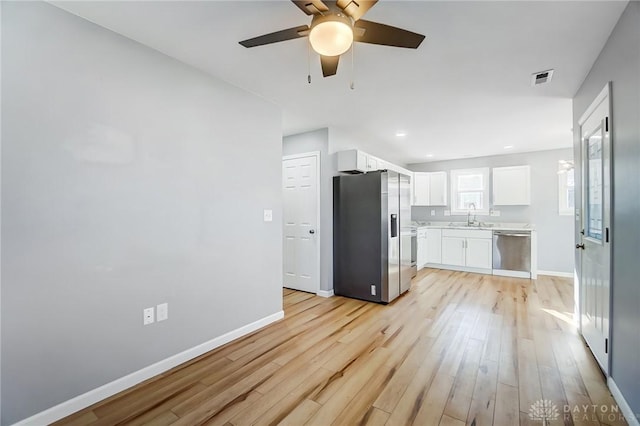 kitchen with white cabinetry, sink, stainless steel appliances, and light wood-type flooring