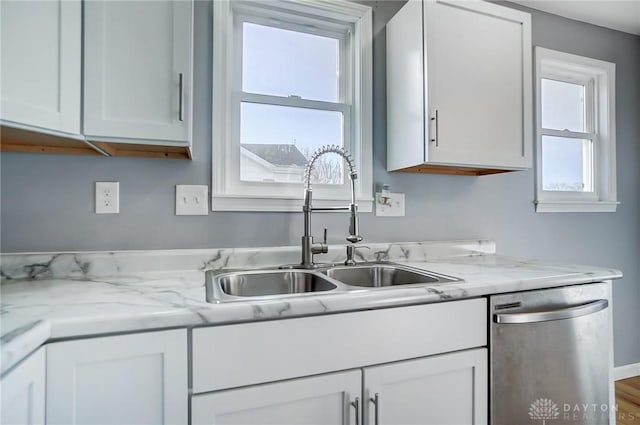 kitchen featuring white cabinets, light stone countertops, sink, and dishwasher