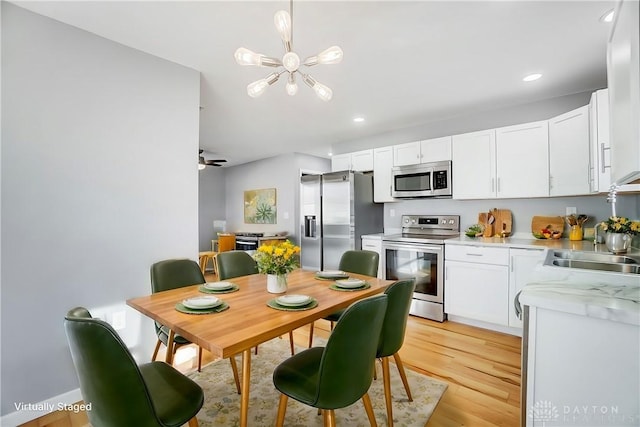 kitchen featuring sink, stainless steel appliances, light hardwood / wood-style floors, and white cabinets