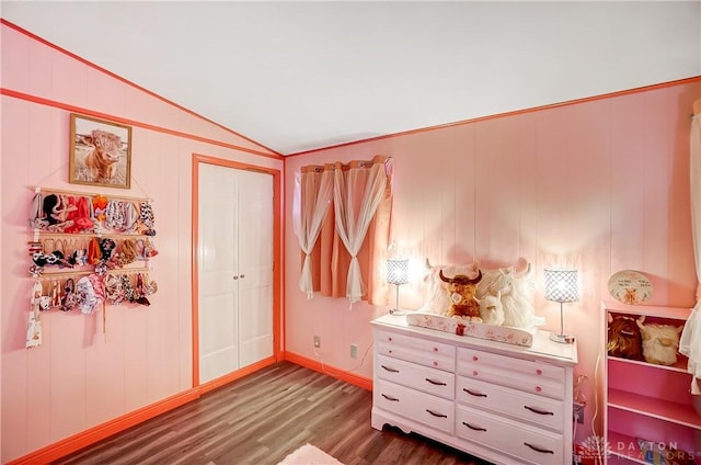 bedroom featuring baseboards, vaulted ceiling, and wood finished floors