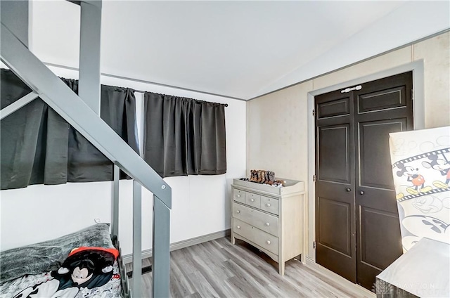 stairs featuring vaulted ceiling and wood finished floors