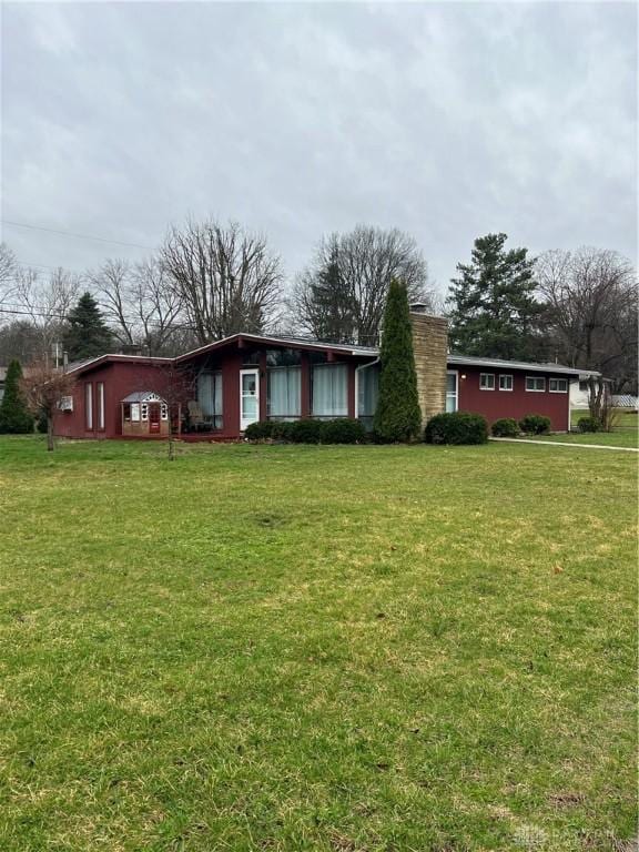 view of front of house with a front yard and a chimney