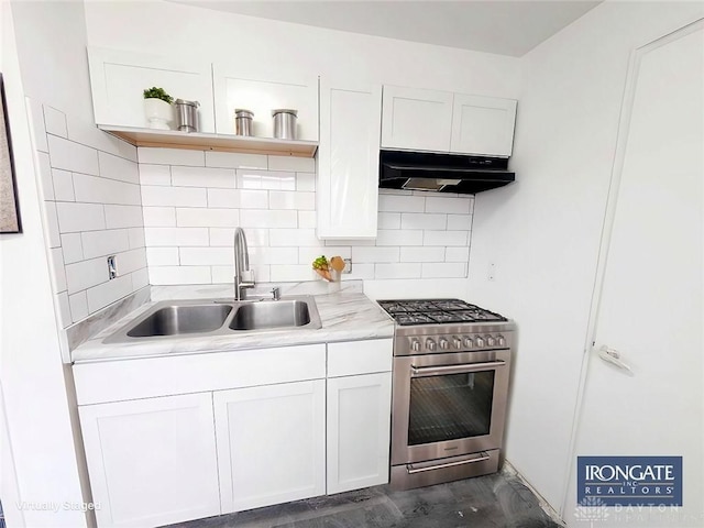 kitchen featuring light countertops, high end stainless steel range oven, under cabinet range hood, and a sink