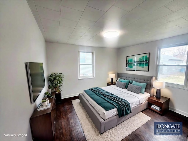 bedroom with wood finished floors and baseboards