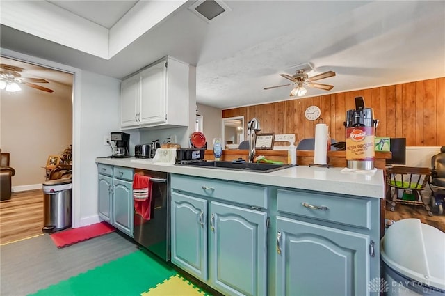 kitchen featuring sink, dark wood-type flooring, blue cabinets, kitchen peninsula, and white cabinets