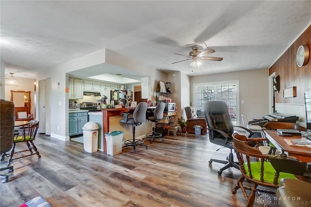 office featuring wood-type flooring, a textured ceiling, ceiling fan, and wood walls