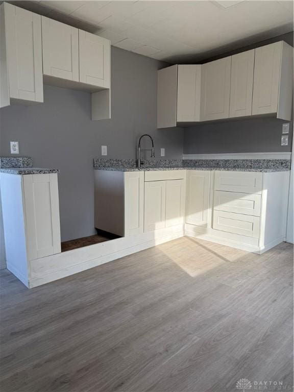 kitchen featuring white cabinetry, sink, and hardwood / wood-style flooring