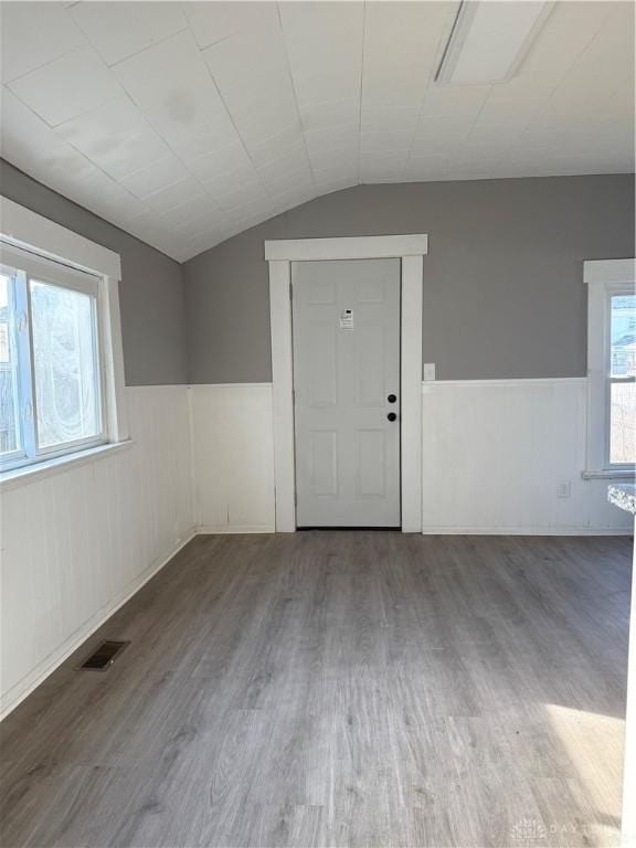 unfurnished room with wood-type flooring and lofted ceiling