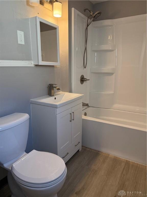 full bathroom featuring shower / bathing tub combination, vanity, hardwood / wood-style flooring, and toilet