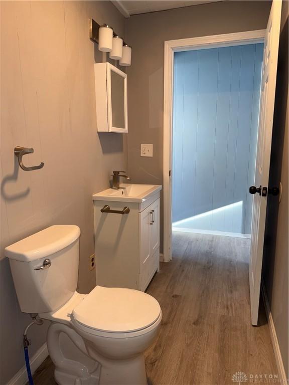 bathroom with toilet, vanity, and hardwood / wood-style flooring