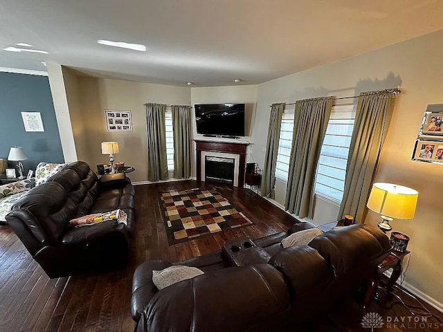 living room with dark hardwood / wood-style flooring and crown molding