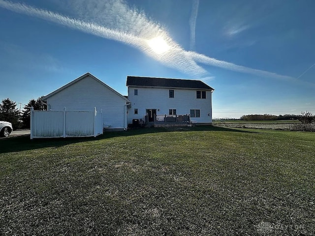 back of property featuring a lawn and a wooden deck