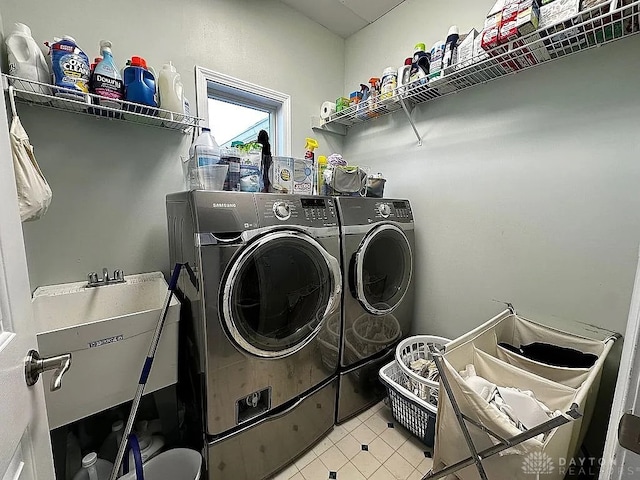 clothes washing area featuring sink and washer and dryer