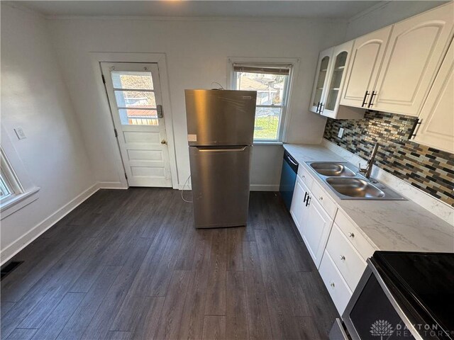 kitchen with tasteful backsplash, white cabinetry, sink, stainless steel appliances, and dark wood-type flooring