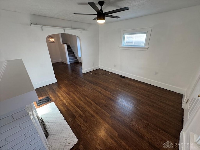 empty room with a textured ceiling, dark hardwood / wood-style floors, and ceiling fan