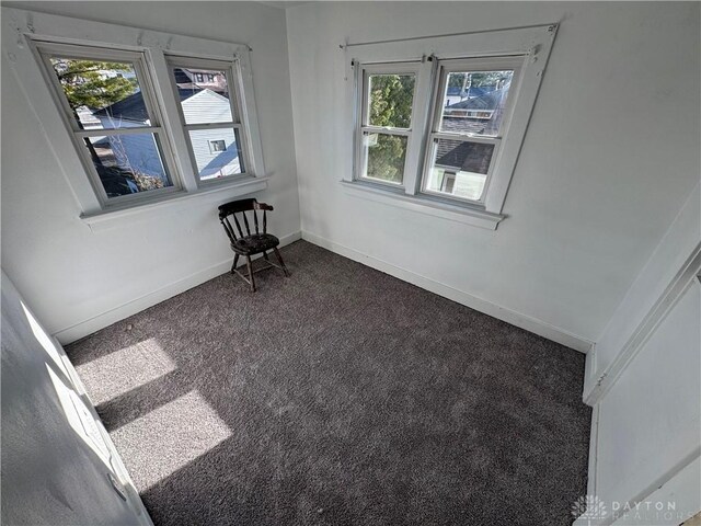 spare room with dark carpet